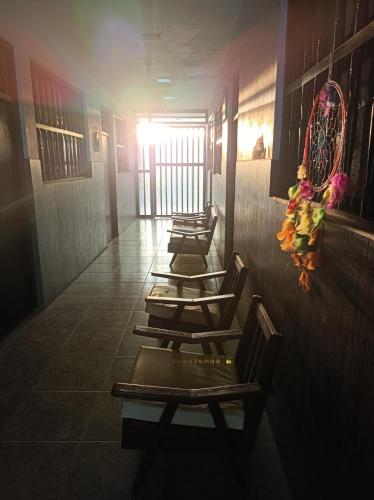 four lounge chairs lined up in a row in a hallway at Casa Colan in Colán