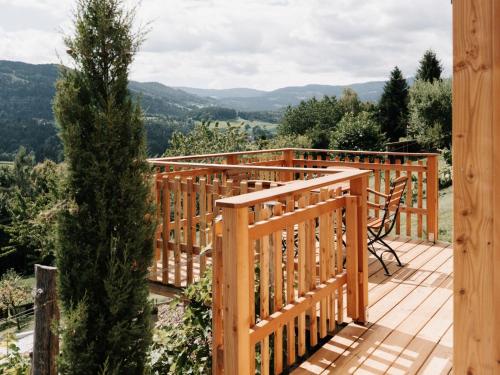 a wooden deck with a bench and a tree at Holiday Home Haus am Kogl by Interhome in Wies