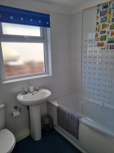 une salle de bain avec un lavabo, des toilettes et une douche dans l'établissement Sandy Cottage, à Clacton-on-Sea