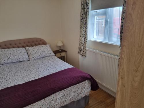 une chambre avec un lit et une fenêtre dans l'établissement Sandy Cottage, à Clacton-on-Sea