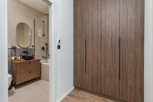 a bathroom with a wooden door and a sink at Penthouse Andro, Omis in Omiš