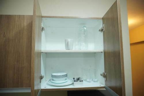 a cupboard with plates and glasses in it at Luxury Suite in Iloilo City