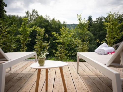 a deck with two white benches and a table at Holiday Home Casa Maria by Interhome in Spert