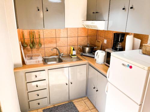 a small kitchen with white cabinets and a sink at Your Home in Argalasti in Argalasti