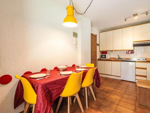 a dining room with a table and yellow chairs at Apartment Tigli by Interhome in Madesimo