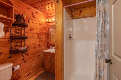 a bathroom with a shower and a toilet and a sink at Forever Yours by American Patriot Getaways in Cove Creek Cascades