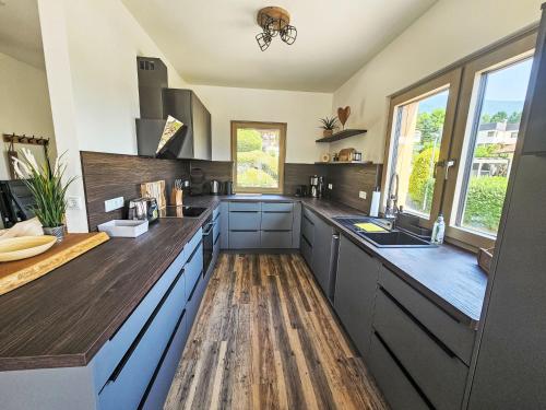 a kitchen with blue cabinets and a wooden floor at Chalet Ossiacher See Chalet 2 by Interhome in Bodensdorf