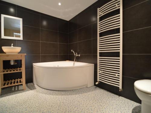 Un baño con bañera, inodoro y lavabo. en Holiday Home in Saint-Omer near Lake & Forest, en Saint-Omer