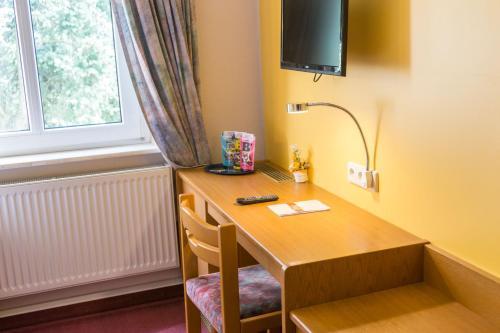 a room with a desk with a lamp and a desk sidx sidx sidx at Hotel zur Post in Wurzen in Wurzen