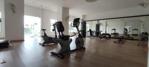 a gym with tread machines and a large mirror at Majestic Sanctuary Homestay Taiping with Netflix - 2 Carpark in Taiping