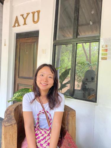 a young girl sitting in front of a building at Zensigiri Ayurveda Wellness Homestay in Sigiriya