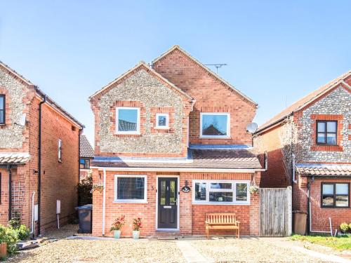 a brick house with a bench in front of it at Seascape in Sheringham