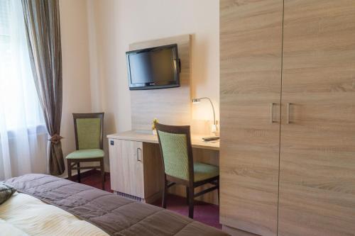 a hotel room with a bed and a desk and a tv at Hotel zur Post in Wurzen in Wurzen