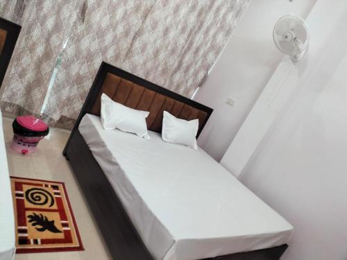 a bedroom with a white bed with a wooden headboard at jp hotel 