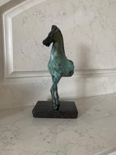 a bronze statue of a dog on a table at Gulbės Apartamentai in Anykščiai