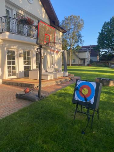 a basketball hoop in the grass in front of a house at Gulbės Apartamentai in Anykščiai
