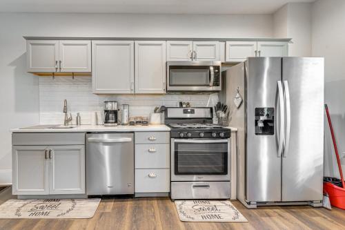 a kitchen with white cabinets and stainless steel appliances at 1 Block to Stroudsburg Main St Chic Townhome in Stroudsburg