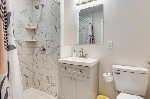 a bathroom with a sink and a toilet and a mirror at 1 Block to Stroudsburg Main St Chic Townhome in Stroudsburg