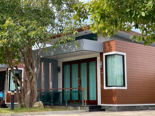a small house with a tree in front of it at Nutchana Hill Boutique Hotel in Ban Thung Ri
