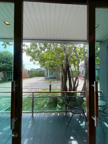 a screened porch with a bench and a tree at Nutchana Hill Boutique Hotel in Ban Thung Ri