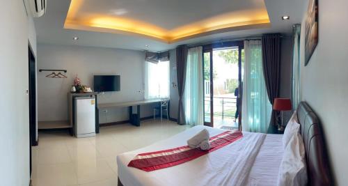 a bedroom with a bed and a desk in a room at Nutchana Hill Boutique Hotel in Ban Thung Ri