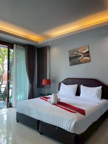 a bedroom with a large bed with a teddy bear on it at Nutchana Hill Boutique Hotel in Ban Thung Ri
