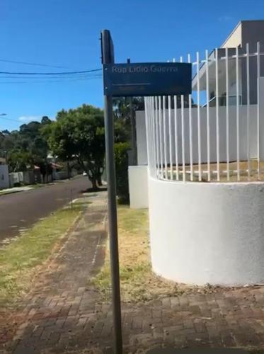 a blue street sign in front of a fence at Morada Felicitá in Pato Branco