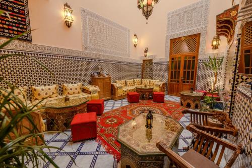 a living room with a couch and tables and chairs at Riad Diamant De Fes in Fès