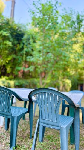 two blue benches sitting next to a table at Retro Lakefront House With A Dock in Balatonvilágos