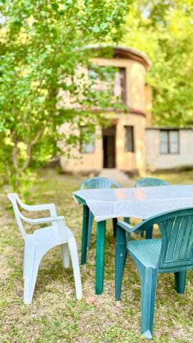 a picnic table and two chairs in front of a building at Retro Lakefront House With A Dock in Balatonvilágos