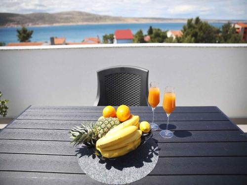 une assiette de fruits sur une table avec deux verres de jus d'orange dans l'établissement Apartments in Starigrad-Paklenica 41220, à Starigrad-Paklenica