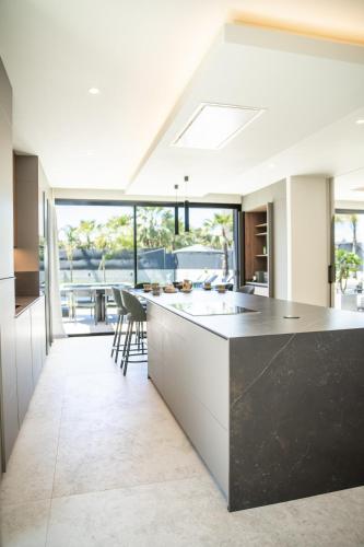 a kitchen with white cabinets and a black counter top at Villa Praya in Valencia in Bétera