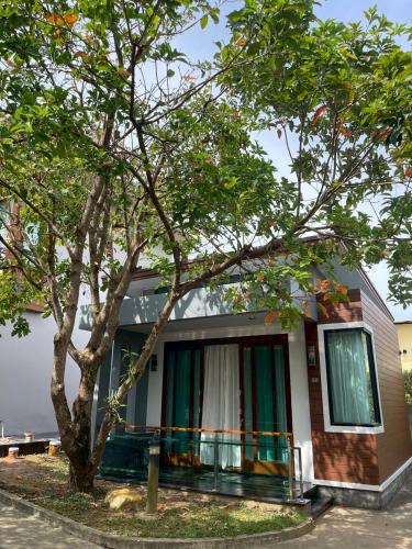 a house with a tree in front of it at Nutchana Hill Boutique Hotel in Ban Thung Ri