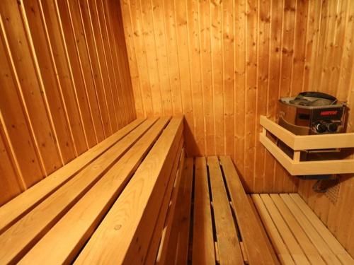 a wooden bench in a sauna with a stove at Chalet Rondins des bois Lac Xonrupt in Xonrupt-Longemer