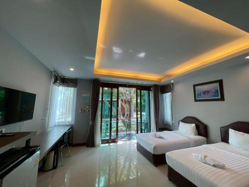 a hotel room with two beds and a television at Nutchana Hill Boutique Hotel in Ban Thung Ri