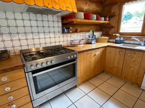 a kitchen with a stove and a sink at Chalet Rondins des bois Lac Xonrupt in Xonrupt-Longemer