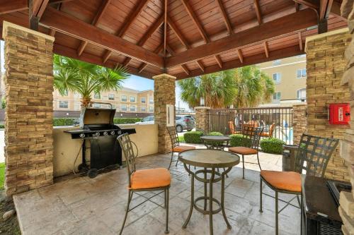 a patio with a grill and a table and chairs at Relux at Westchase in Houston