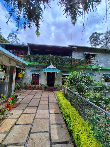 a building with a patio with an umbrella on it at Casa Linda in Devikolam