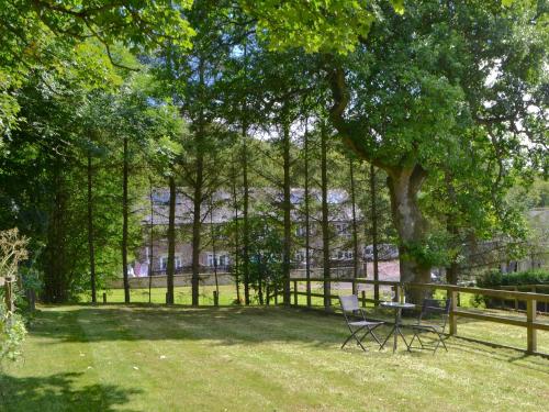 a park with a table and chairs under a tree at Oak Tree Barn - 27693 in Otterburn