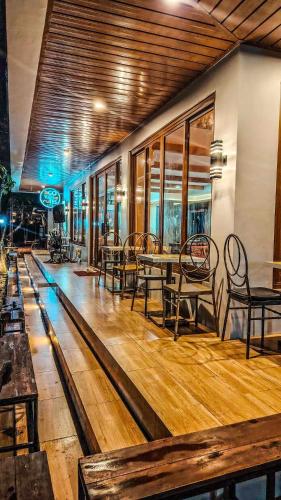 a restaurant with wooden floors and tables and chairs at The River House - Govantes Guesthouse in Vigan
