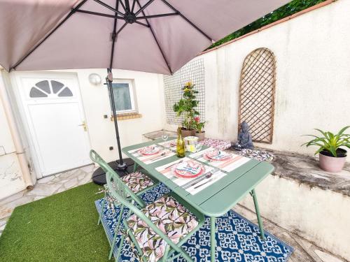 a table and chairs under an umbrella on a patio at EXIGEHOME-Large studio with terrace 15 min Paris-La Défense in Suresnes