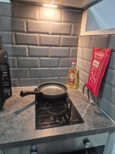 a pan sitting on top of a stove in a kitchen at The Orange Outpost 8a - City Centre in Bradford
