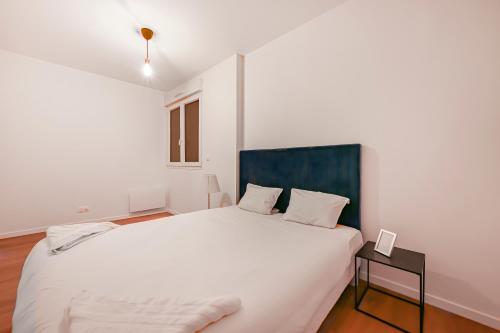 a bedroom with a large white bed and a table at CityLodge Evreux - Spacieux 40m2 1 ch Parking WiFi - Proche Centre & Gare in Évreux