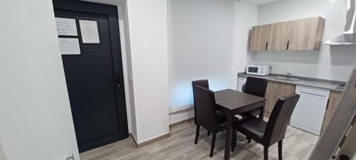 a small kitchen with a black door and a table and chairs at El Rincón de Perez A in Ajo