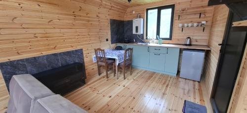 a kitchen in a log cabin with a table and chairs at Belas guesthouse in Stepantsminda