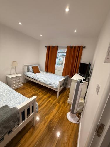 Un dormitorio con dos camas y un televisor. en Bel Great, en Londres