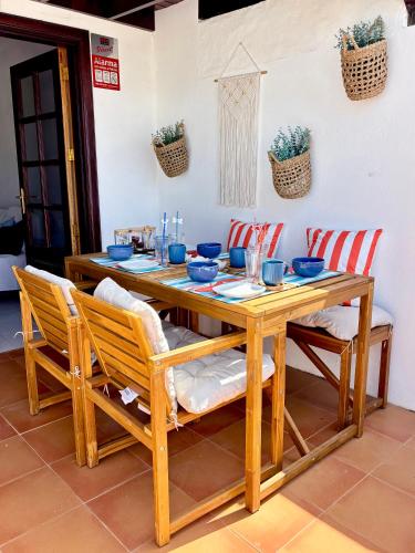a wooden table with chairs and a dining room at La Necora Lanzarote in Playa Honda