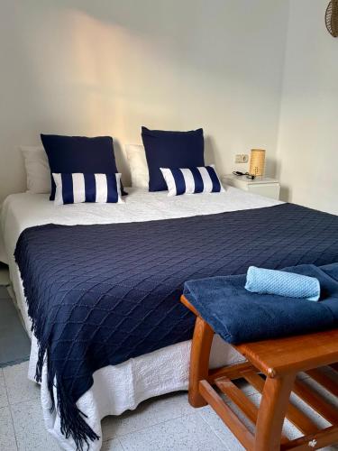 a bedroom with a large bed with blue and white pillows at La Necora Lanzarote in Playa Honda