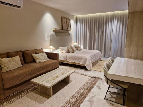 a living room with a couch and a bed at Beautiful Studio Puerto Morelos in Puerto Morelos