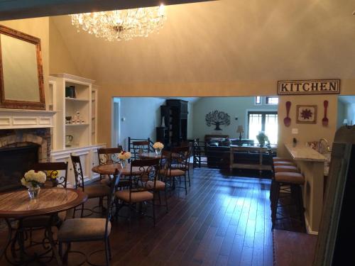 a restaurant with tables and chairs and a fireplace at Maple Creek Bed&Breakfast in Tomball